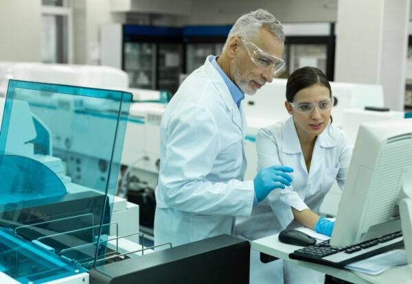 Delighted mature researcher wearing protective glasses while working in laboratory