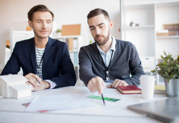 Portrait of real estate agent helping client choosing house in agency
